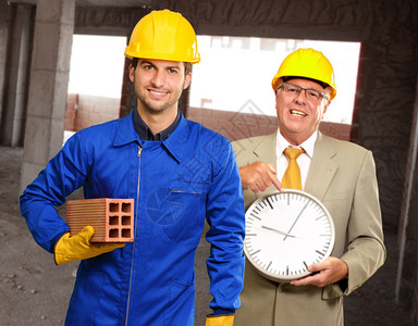 两名建筑工程师持时钟和砖头图片