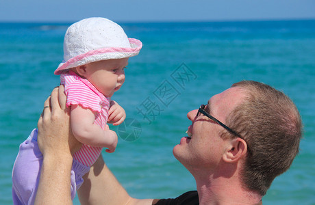 父亲和女儿一起在海滩上图片
