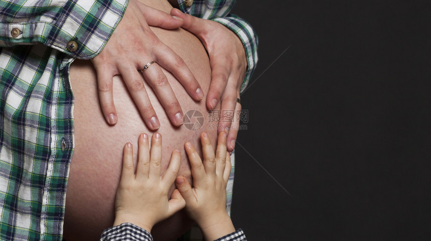 孩子的手放在孕妇的肚子上图片
