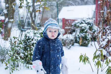 可爱的小孩男的肖像在美丽的冬季雪图片