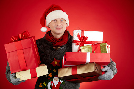 圣诞老人帽中快乐男人的肖像拿着礼物盒图片