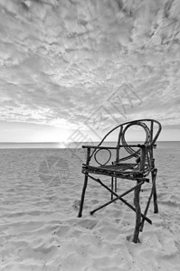 坐在桑迪海滩和海边的老竹子座椅上把太阳定在戏图片