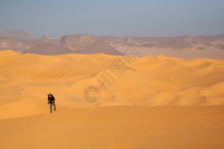 走在沙漠的摄影师图片