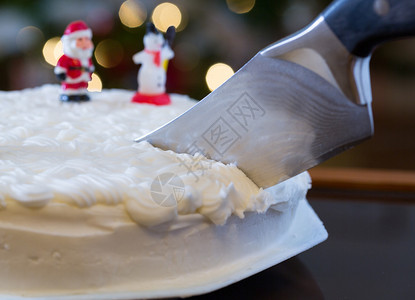 冰冷的圣诞蛋糕被切出背景中Xmas树图片