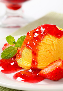 一勺黄色冰淇淋配草莓酱图片