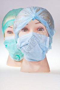 两名身戴纺织外科手术帽和医疗保护面罩的图片