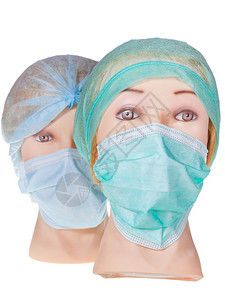 两名身戴纺织外科手术帽和白底隔离的医用保护面具的女图片