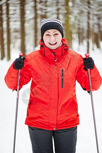 一个在冬季树林里带着滑雪杆的快图片