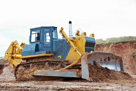 在沙采石场进行挖土作业的履带型运货车背景图片