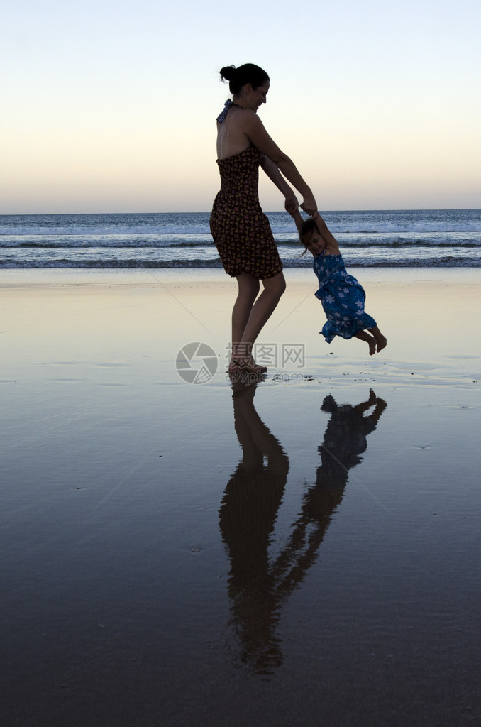 沙滩上玩耍的母女剪影图片