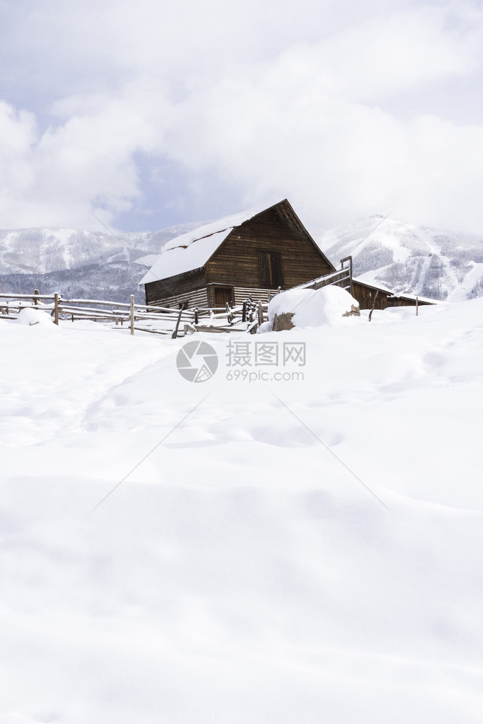 雪地山坡上的谷仓背面有滑雪图片
