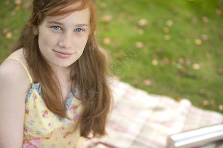 红发少女坐在森林的毯子上时图片