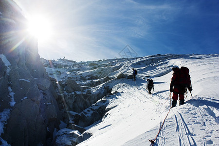 一群登山者在冰川上的绳索上山上阳图片