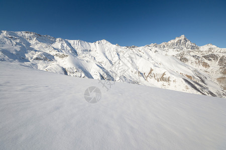 地表背景和雪坡中高山脉的全景高清图片