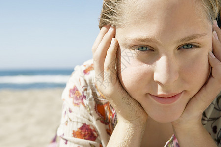 一个女孩躺在金沙滩上笑着微笑图片