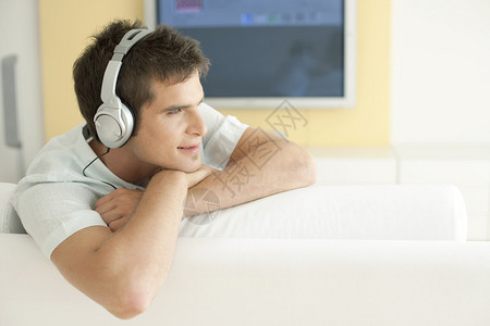 年轻人在家里用耳机听音乐图片