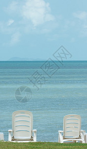 泰国蓝色伞和白色椅子的海景图含背景图片