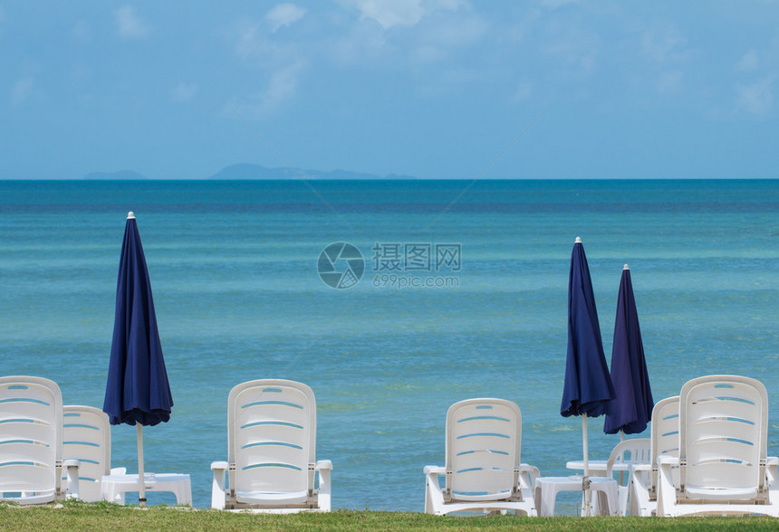 泰国蓝色伞和白色椅子的海景图含图片