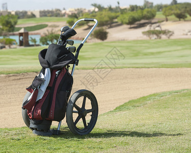 高尔夫球车和包袋在高尔夫球场上图片