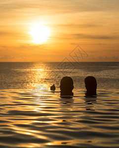 在日落时俯瞰大海的无边泳池边缘图片