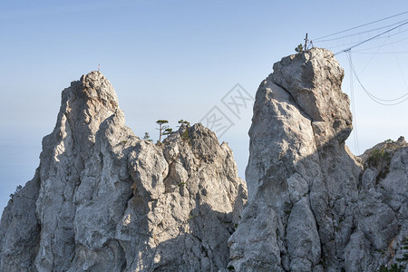 两座悬崖和两座固定在岩石上的攀山和拉皮条设备图片