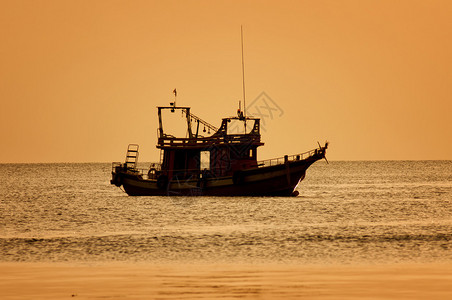 日落热带海滩上乘船图片