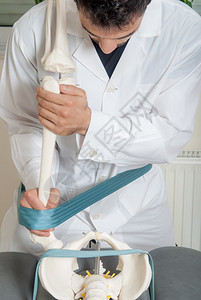 由男物理治疗师对训练塑料脊柱和女患者进行的手动物理和背景图片