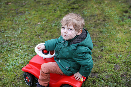 在春天花园玩大具车的小男图片