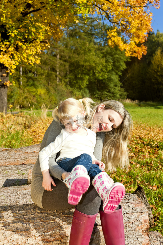 母亲带着她的小女儿在秋天的大自然中图片