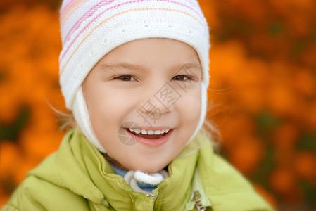 绿色夹克特写镜头的美丽微笑的小女孩图片