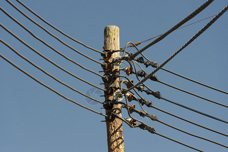 在蓝天背景的电力线电缆图片