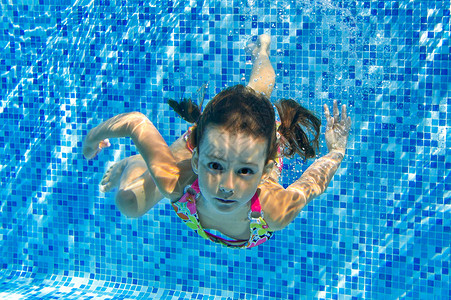 快乐活跃的孩子在游泳池水下游泳图片
