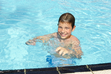 在游泳池上的活动可爱男孩游泳和在图片