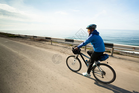 在海滩上骑着自行车旅行的旅游者看着图片