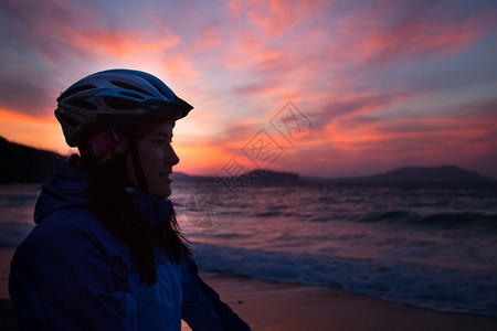 带着自行车的女孩站在沙滩上看图片