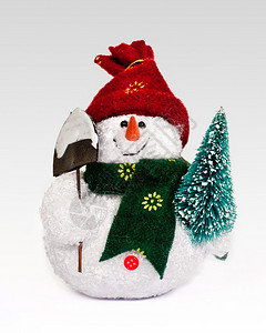 拿着铲子和圣诞树的雪人玩具雕像图片