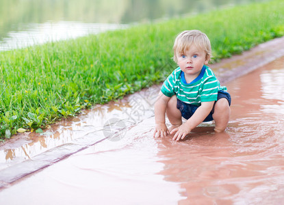 孩子雨后在水坑里玩耍图片