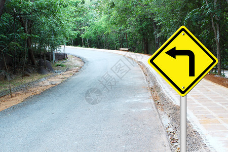在弯道上左转警告标志背景图片