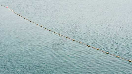 有浮标的绳索在海背景图片