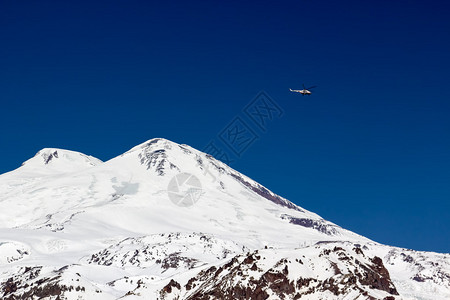 厄尔布鲁士山的救援行动直升机在山上寻找图片