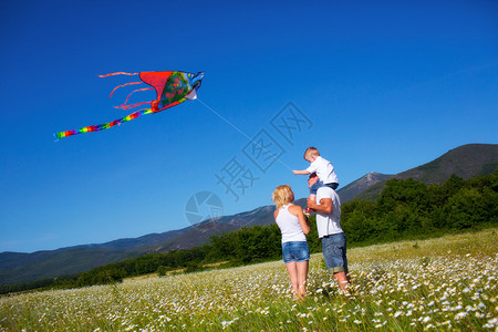一家人在花草甸上玩风筝图片