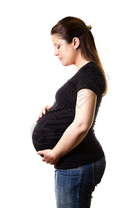 美丽的孕妇看着肚子的美丽孕妇在白种背景图片