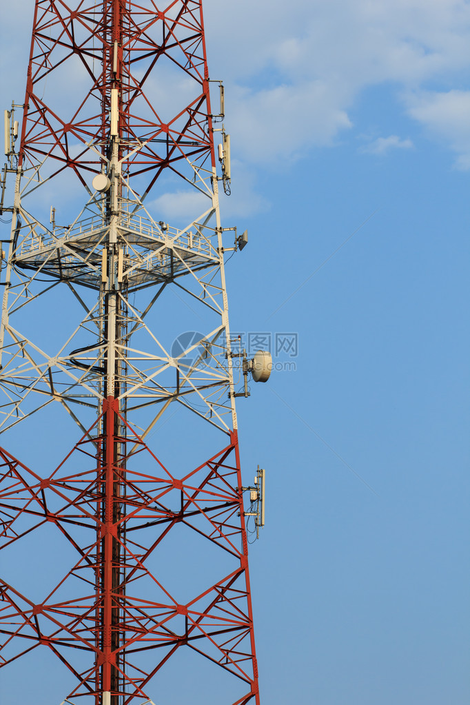 巨大的通信天线塔和卫星碟形天线映衬着蓝天图片