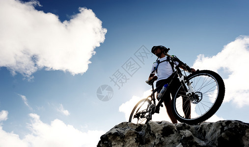 自信的山地自行车骑手站着观察风景图片