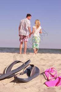 在海边和拖鞋的热恋中的情侣图片