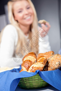 早餐桌上的面包篮里新鲜全麦卷和羊角面包图片