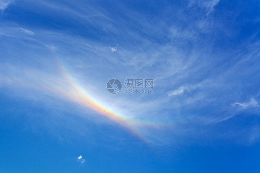 蓝色夏日午后天空中的彩虹图片