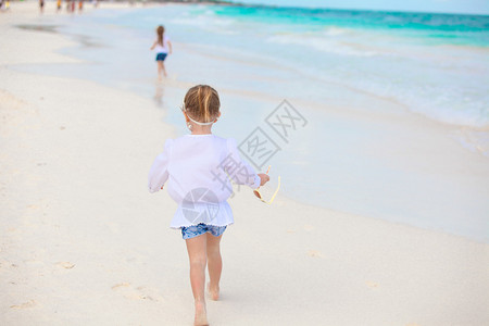 小女孩在墨西哥的白色沙滩上奔跑图片