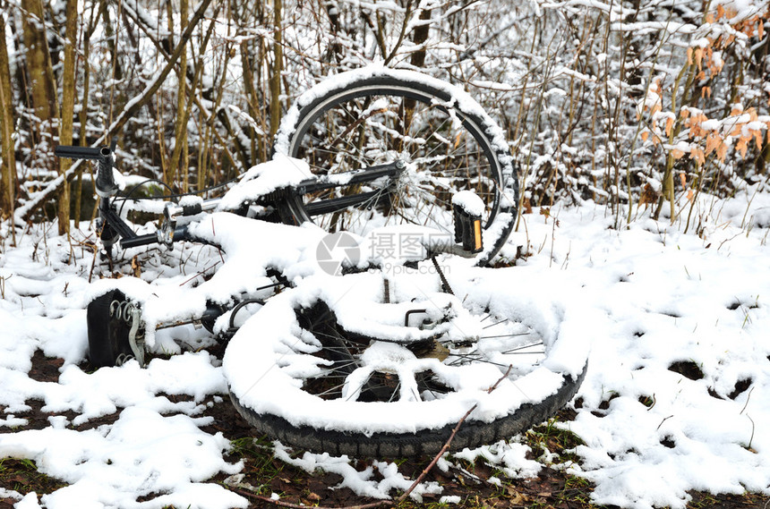 一辆废弃的自行车躺在冬季公园里图片