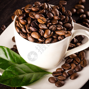 杯咖啡豆和咖啡叶图片